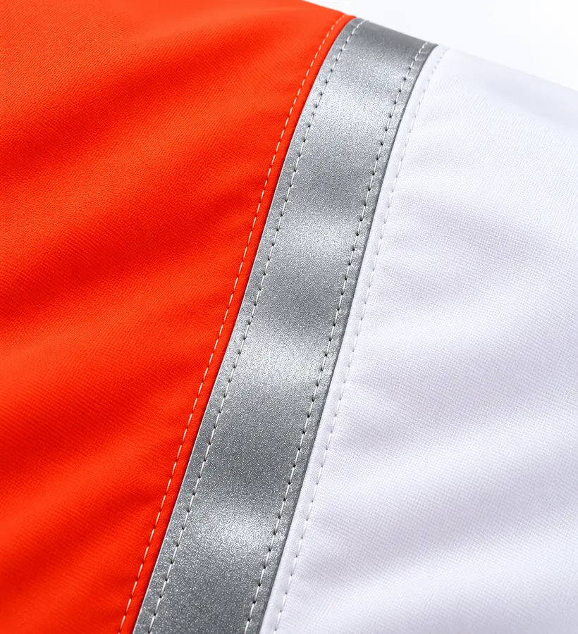 Close-up of red and white windsock fabric with silver reflective tape and neat stitching along its edges.